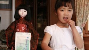 富士山水素（Made In Japan）の１個の人形の隣に小さな女の子が立っています。