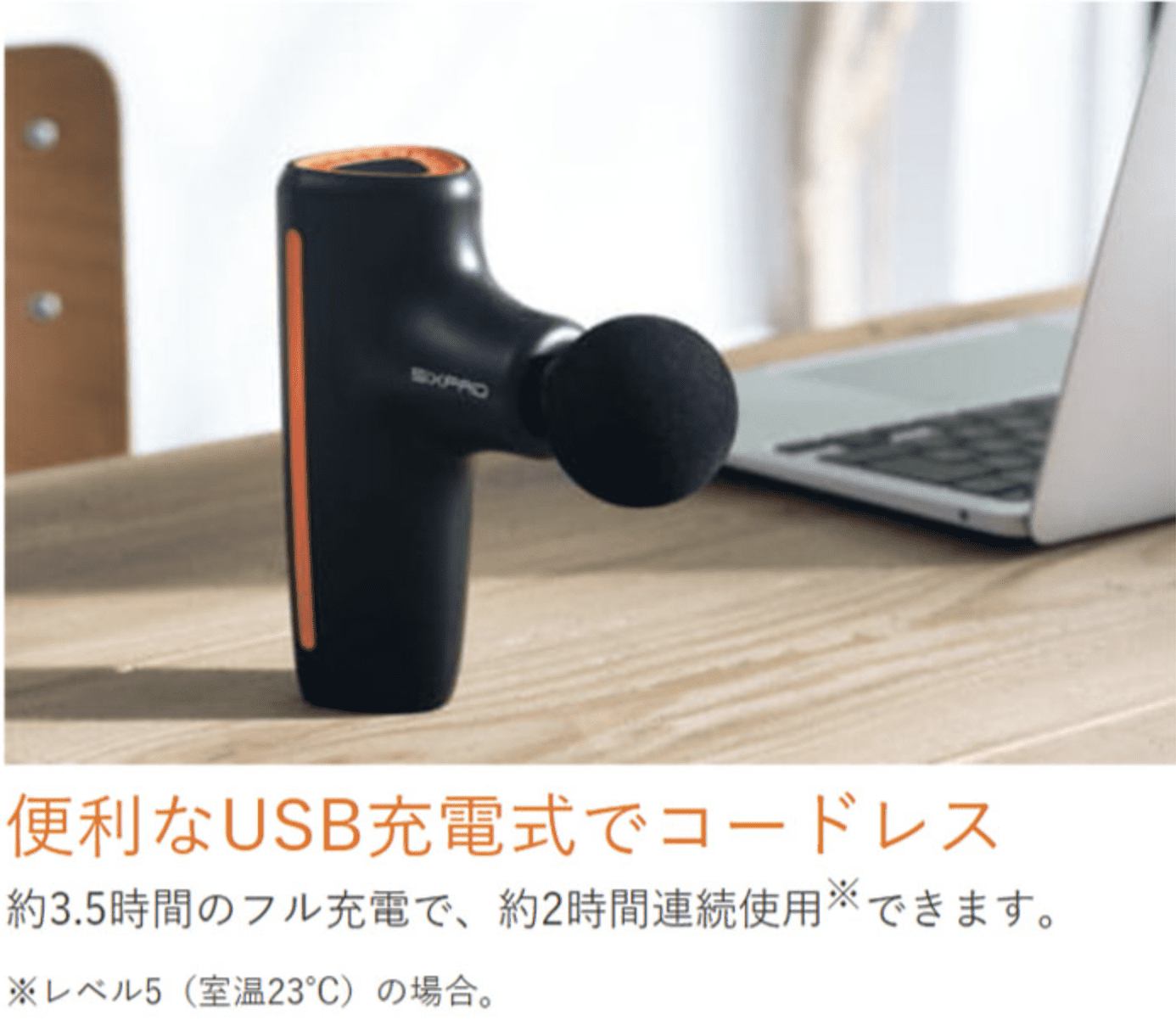 黒とオレンジの手持ち式マッサージ デバイスである SIXPAD パワー ガンがテーブルの上に置かれています。上の日本語のテキストは、USB 充電式でコードレスで、約 3.5 時間の充電で 2 時間の連続使用が可能であることを示しています。 コンパクト＆軽量設計で全身セルフケアに最適です。