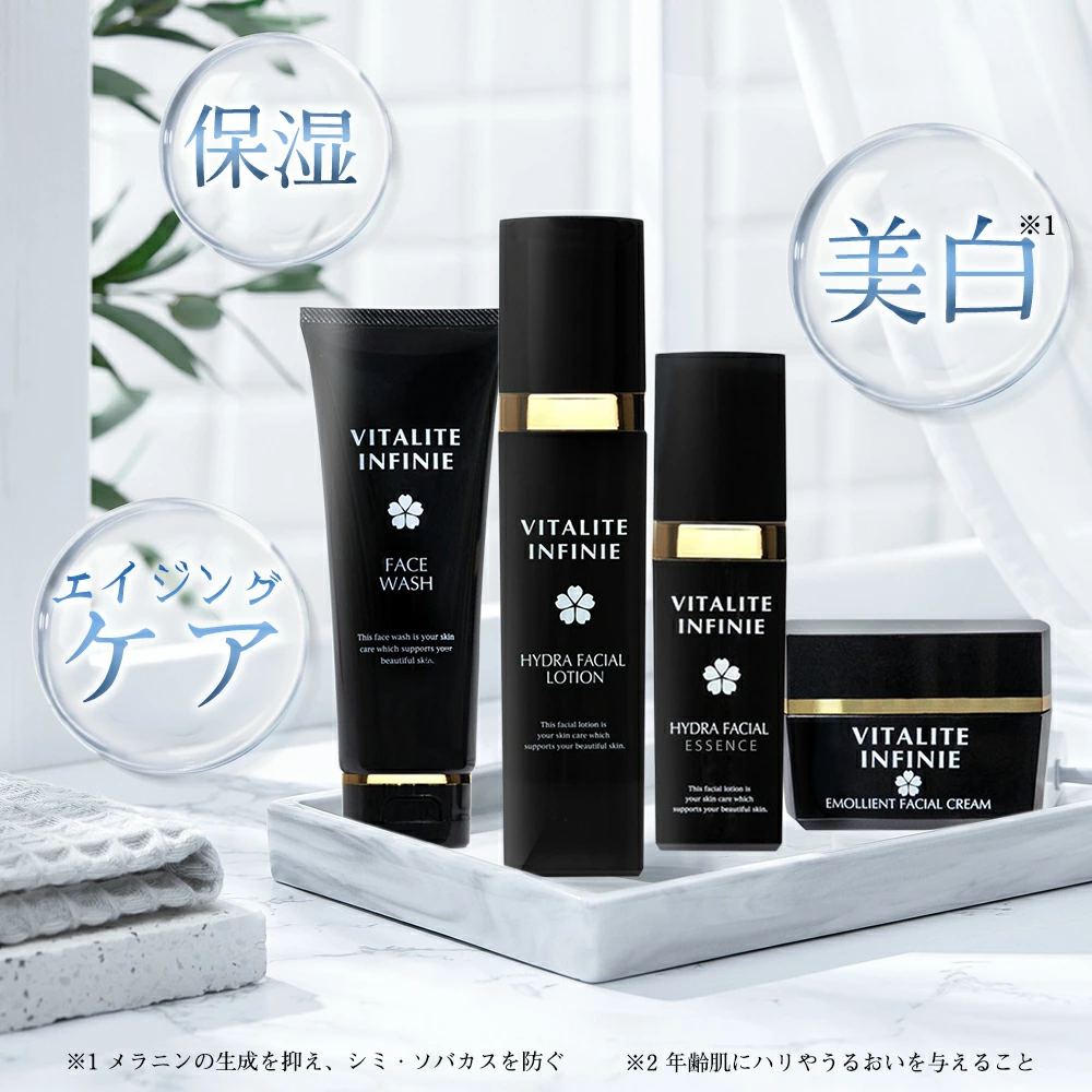 洗顔料、化粧水、美容液、エモリエントクリームをセットにした新世代のヴィタライト インフィニ エイジング スキンケア セットが、明るい部屋のトレイに上品に並べられています。.