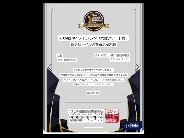 上部に金色の「世界消費者満足度賞」のエンブレム、ペット消臭用クリーンスメルの詳細を示す日本語のテキスト、およびエッジに沿った黒と金の装飾アクセントを備えた日本の賞状。.