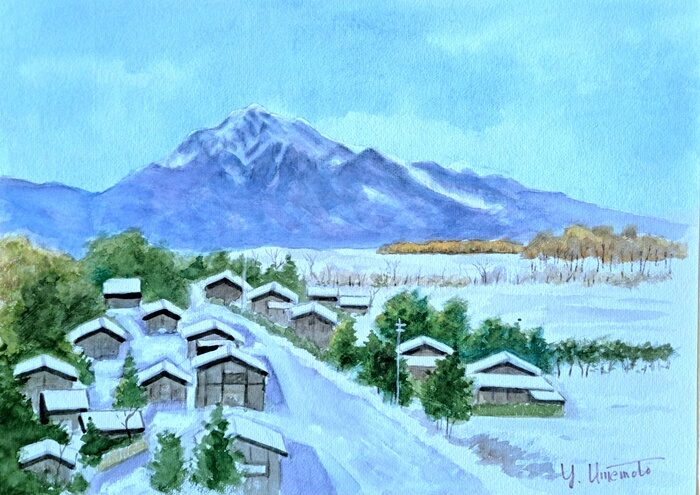 木々に囲まれ、道路沿いに小さな家が並ぶ雪の村。背景には快晴の青空の下、甲斐駒ヶ岳がそびえ立っています。静かな情景が冬の風景水彩画の魅力を呼び起こします。.