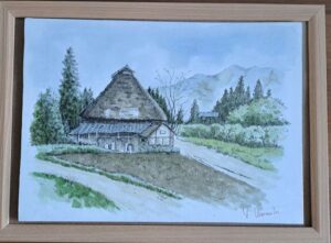 山麓にある素朴な茅葺き屋根の家。木々に囲まれ、土の道が家へと続いています。遠くの山々（おそらく常念岳）を背景に、額装された風景水彩画です。右下隅に作者の署名があります。.