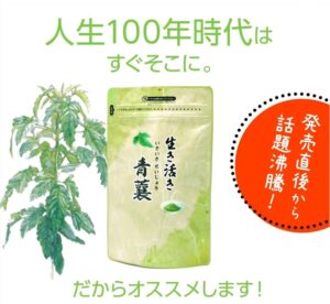 「生きいき青襄」と書かれた緑色のハーブサプリメントの袋が、葉の茂った植物の中に飾られています。緑色の日本語の宣伝文とその右側にオレンジ色のバッジがあり、青襄の人気を強調しています。.