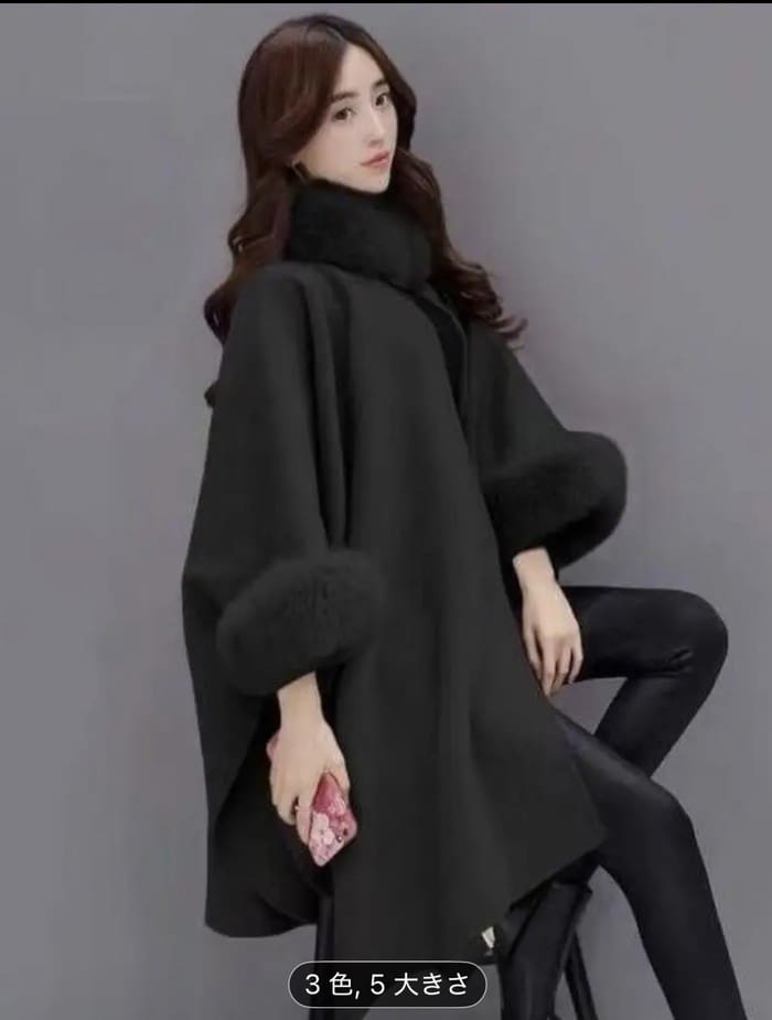 茶色のロングヘアの女性が、襟と袖口にファーがあしらわれたスタイリッシュなブラック・レディースコートを着て、黒いレギンスをはき、ピンクの携帯電話を持っている。無地のグレーを背景にポーズをとっている。.