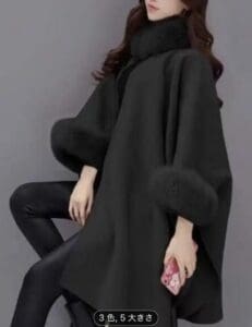 毛皮の縁取りが施された黒のレギンスに身を包み、ピンクの携帯電話ケースを持つ女性。ウェーブのかかった髪はゆるく、無地のグレーを背景に立つ彼女の顔を部分的に隠している。.