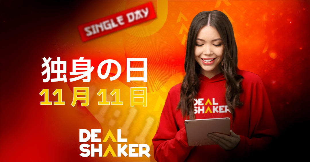 赤いDealShakerのパーカーを着た笑顔の女性がタブレットを見ている。赤とオレンジの背景には、独身の日、日本語のテキスト、11月11日、お得、DealShakerのロゴが描かれています。.
