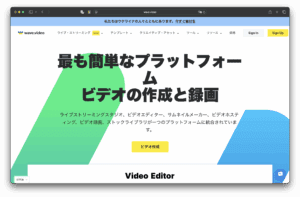 WAVE.VIDEOの日本語サイトが表示され、簡単なビデオ作成と録画を宣伝する黒い太字のテキスト、背景のカラフルな幾何学図形、「ビデオ作成」と書かれた目立つ黄色のボタンが特徴的だ。.