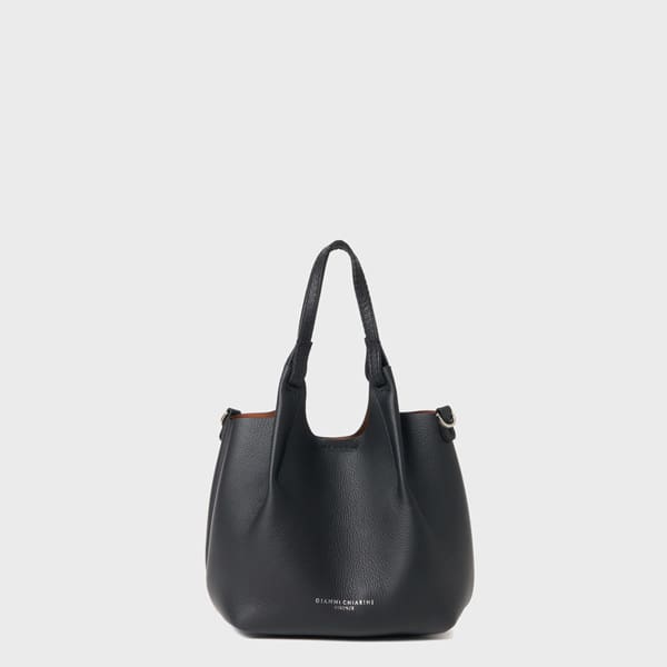 GIANNI CHIARINI（ジャンニ キアリーニ）のブラックレザートートバッグ。2つのハンドル、繊細なテクスチャー、シルバーの金具が、プレーンなライトグレーの背景に映えます。前面には小さな文字でブランド名「ジャンニキアリーニ」がプリントされています。.